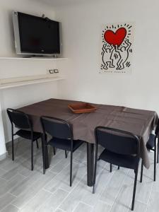 a dining room table with chairs and a heart on the wall at Porta Maia in Urbino