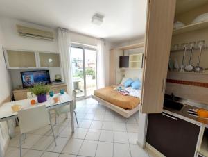 a small room with a bed and a kitchen at Residence Il Tulipano in Riccione