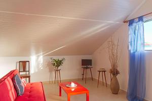 a living room with a red couch and a red table at Casa Alto Santo António in Ponta do Sol