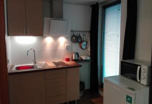 een kleine keuken met een wastafel en een magnetron bij Vila Real Loft 360º in Vila Real