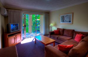 Bila Vista Kirra Beachside Apartments في غولد كوست: غرفة معيشة مع أريكة وتلفزيون