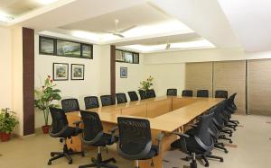 een grote vergaderzaal met een lange tafel en stoelen bij Ahuja Residency Parklane, Gurgaon in Gurgaon