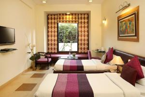 古爾岡的住宿－Ahuja Residency Parklane, Gurgaon，一间酒店客房,设有两张床和电视