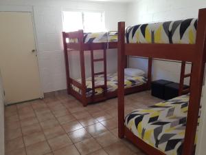 a room with three bunk beds and a window at Apurla Island Retreat in K'gari Island (Fraser Island)