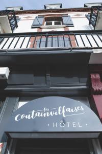 a sign for a columbus hotel on a building at Hôtel Les Coutainvillaises in Agon Coutainville