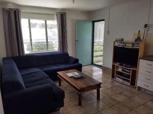 a living room with a blue couch and a coffee table at Apurla Island Retreat in K'gari Island (Fraser Island)