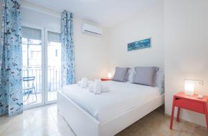 a white bedroom with a bed and a balcony at Be Barcelona Eixample Urquinaona II in Barcelona