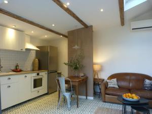 a kitchen and living room with a couch and a table at La Summer House avec Jardin in Arles
