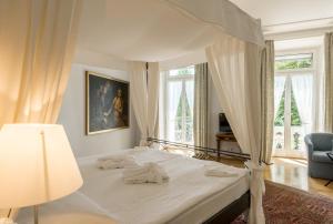 ein Schlafzimmer mit einem Himmelbett und einem Stuhl in der Unterkunft Grand Hotel Europe in Luzern