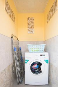 a washing machine in a bathroom with a yellow wall at Camping 3 Gs in Goghtʼ