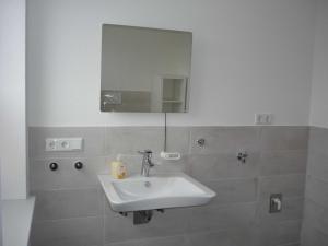 a bathroom with a sink and a mirror at Ferienhaus Carstensen - gemütlich und rollstuhlfreundlich eingerichtetes Ferienhaus mit Terrasse in Janneby