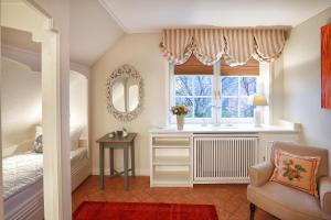 a bedroom with a bed and a window and a chair at Ferienwohnung Biberhüs OG in Archsum