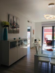 uma cozinha e sala de estar com uma mesa de vidro em Apartament Orhidea em La Mata
