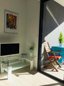 sala de estar con TV y silla en Apartament Orhidea en La Mata