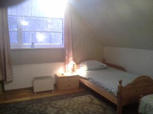 a small bedroom with a bed and a window at Koidu Homestay in Haapsalu