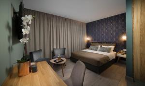 pokój hotelowy z łóżkiem, stołem i krzesłami w obiekcie Diana Hotel w mieście Hajfa