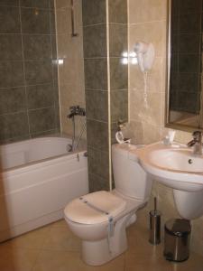 a bathroom with a toilet and a sink at Hotel Elegance in Asenovgrad