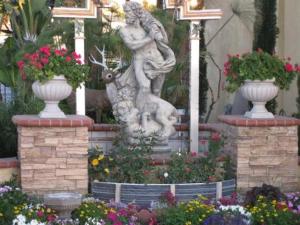 a statue of a woman hugging a rabbit in a garden at The Palace Inn in Oxnard