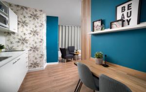 a kitchen and dining room with blue walls and a wooden table at Diana Hotel in Haifa +16 photos