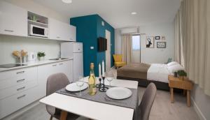 a room with a bed and a dining table and a kitchen at Diana Hotel in Haifa