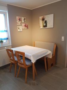a table and two chairs with a white table and a window at Petite Belle in Volkertshausen