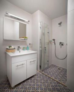 a bathroom with a white sink and a shower at Diana Hotel in Haifa