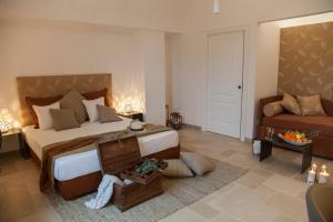 um quarto com uma cama grande e um sofá em Ottolire Resort em Locorotondo