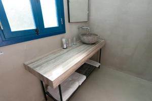 a bathroom with a counter with a sink and a mirror at Hylatio Tourist Village in Pissouri