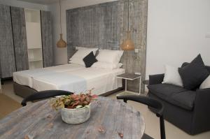 a bedroom with a bed and a table and a couch at Hylatio Tourist Village in Pissouri