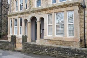 an old stone building with windows on a street at Harrogate Serviced Apartments - St George's Five in Harrogate