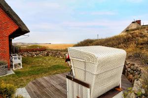 a white refrigerator sitting on top of a wooden deck at Ferienwohnung Dikstig Rechts in Kampen