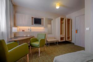 a room with two chairs and a table and a tv at Hotel Reytan in Warsaw