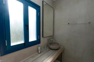 a bathroom with a sink with a mirror and a window at Hylatio Tourist Village in Pissouri