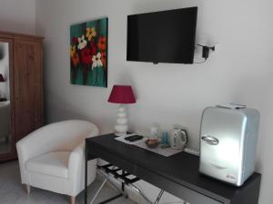 a room with a desk with a refrigerator and a chair at B&B Il Belvedere in Guardialfiera