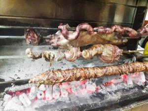 een groep vlees en worsten die op een grill koken bij Natasa Rooms in Filippaioi