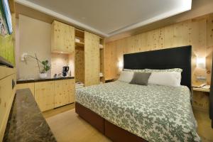 una camera con un grande letto e pareti in legno di Hotel St. Michael a Livigno