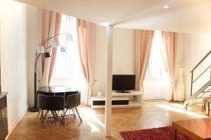 un salon avec une table et une télévision dans l'établissement AzurAppart Elegant Studio Centre, à Nice