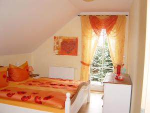 a bedroom with a bed and a window at Ferienhaus Vogtlandresidenz in Auerbach