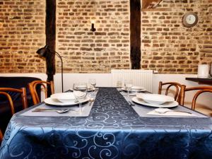 a table with chairs and a blue table cloth on it at Nice apartments in a monumental square farm in Richelle