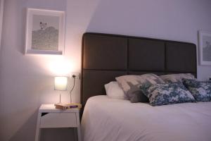 サンタクルス・デ・テネリフェにあるVacacional Anaga ideal descanso parking gratuitoのベッドルーム1室(ベッド1台、ランプ付きのナイトスタンド付)