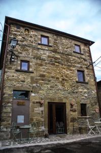 un edificio in pietra con delle sedie di fronte di Antica Dimora del Pellegrino ad Anghiari