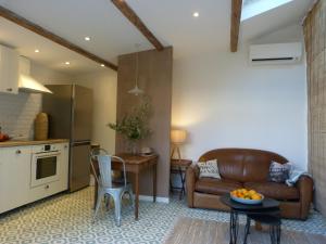 uma cozinha e uma sala de estar com um sofá e uma mesa em La Summer House avec Jardin em Arles