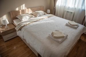 a bedroom with a large bed with two towels on it at Apartment Ada in Belgrade