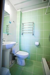 a green bathroom with a toilet and a sink at Villa Marmaris in Rybachye