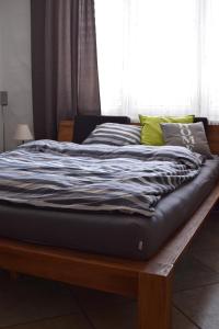 ein großes Bett mit einem Holzrahmen vor einem Fenster in der Unterkunft BnB Villa Levanta in Péry