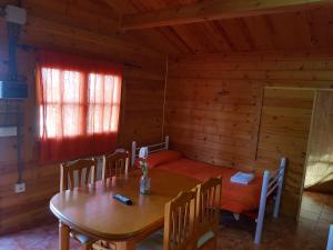 comedor con mesa y sillas en una cabaña en Camping Ruta del Purche, en Monachil