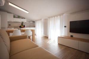 a living room with a couch and a flat screen tv at Residence Torino in Chioggia