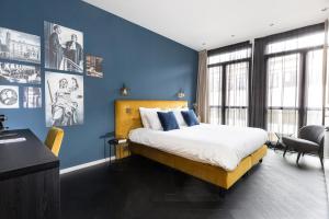 a bedroom with a large bed with blue walls at Court Hotel Utrecht City Centre in Utrecht +50 photos