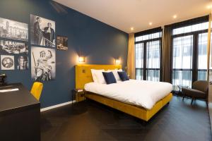 a bedroom with a bed with a blue wall at Court Hotel Utrecht City Centre in Utrecht