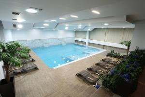 ein großes Schwimmbecken in einem Raum mit Stühlen in der Unterkunft Hotel Zenica in Zenica